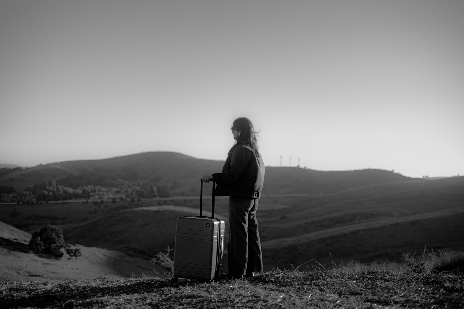 Eminence hardside luggage on a hillside at sunset — Dejuno
