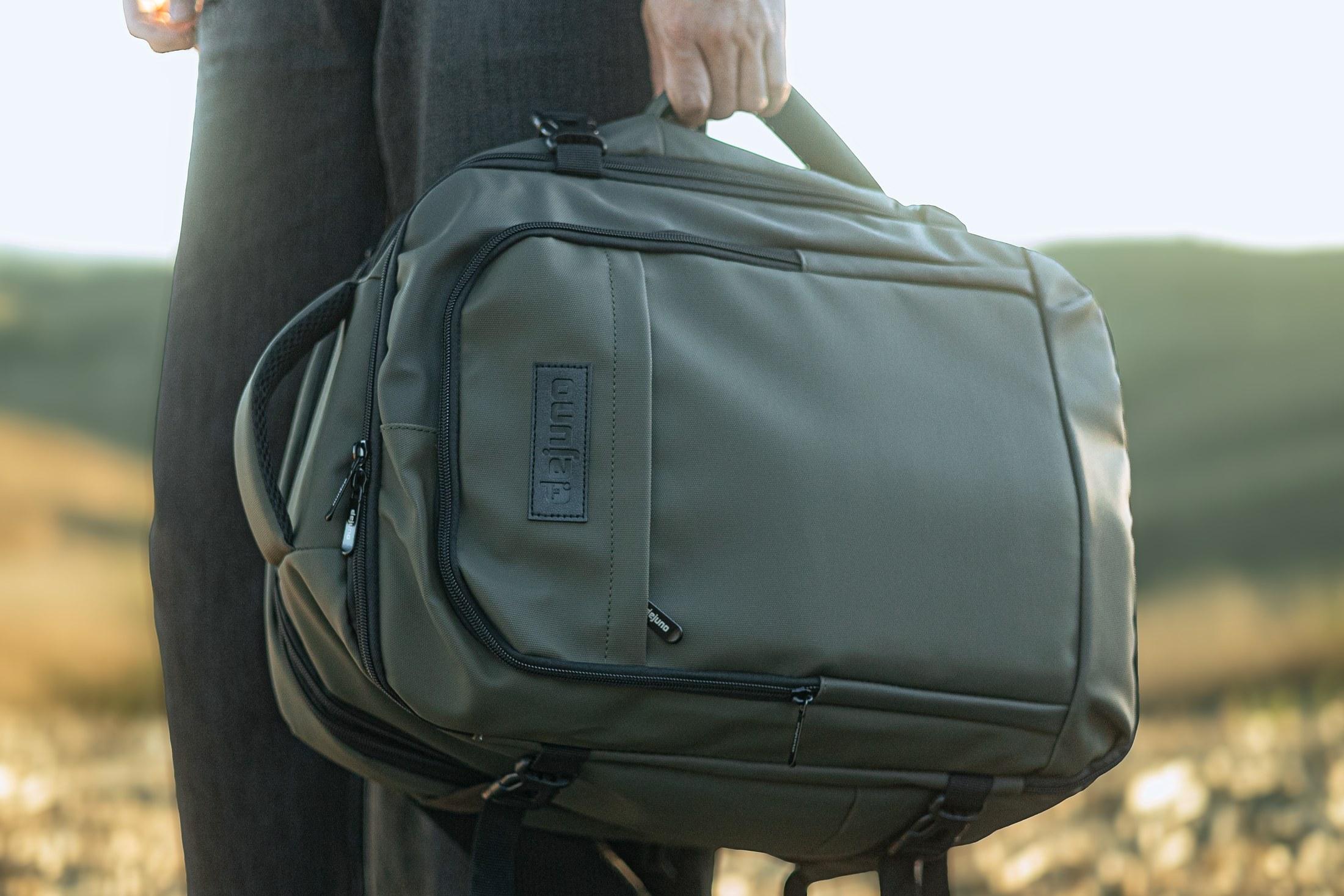Weekender bag held by its handle, close lifestyle shot